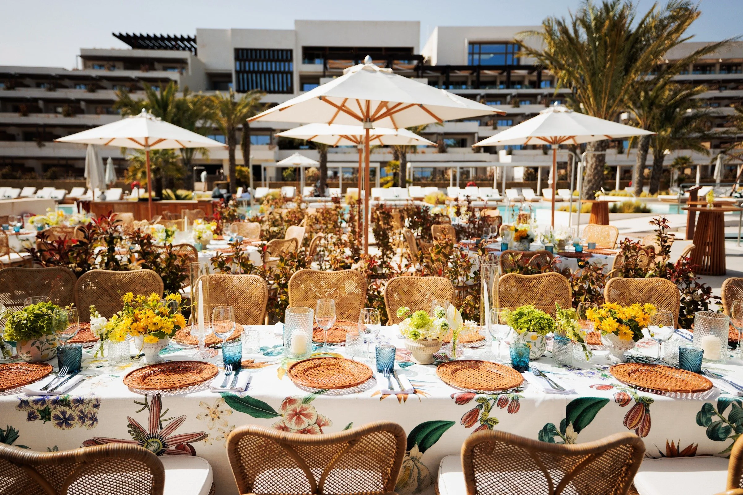 Aerial view of luxury outdoor corporate summit dinner with white umbrellas and floral tablescapes — Grove Projects