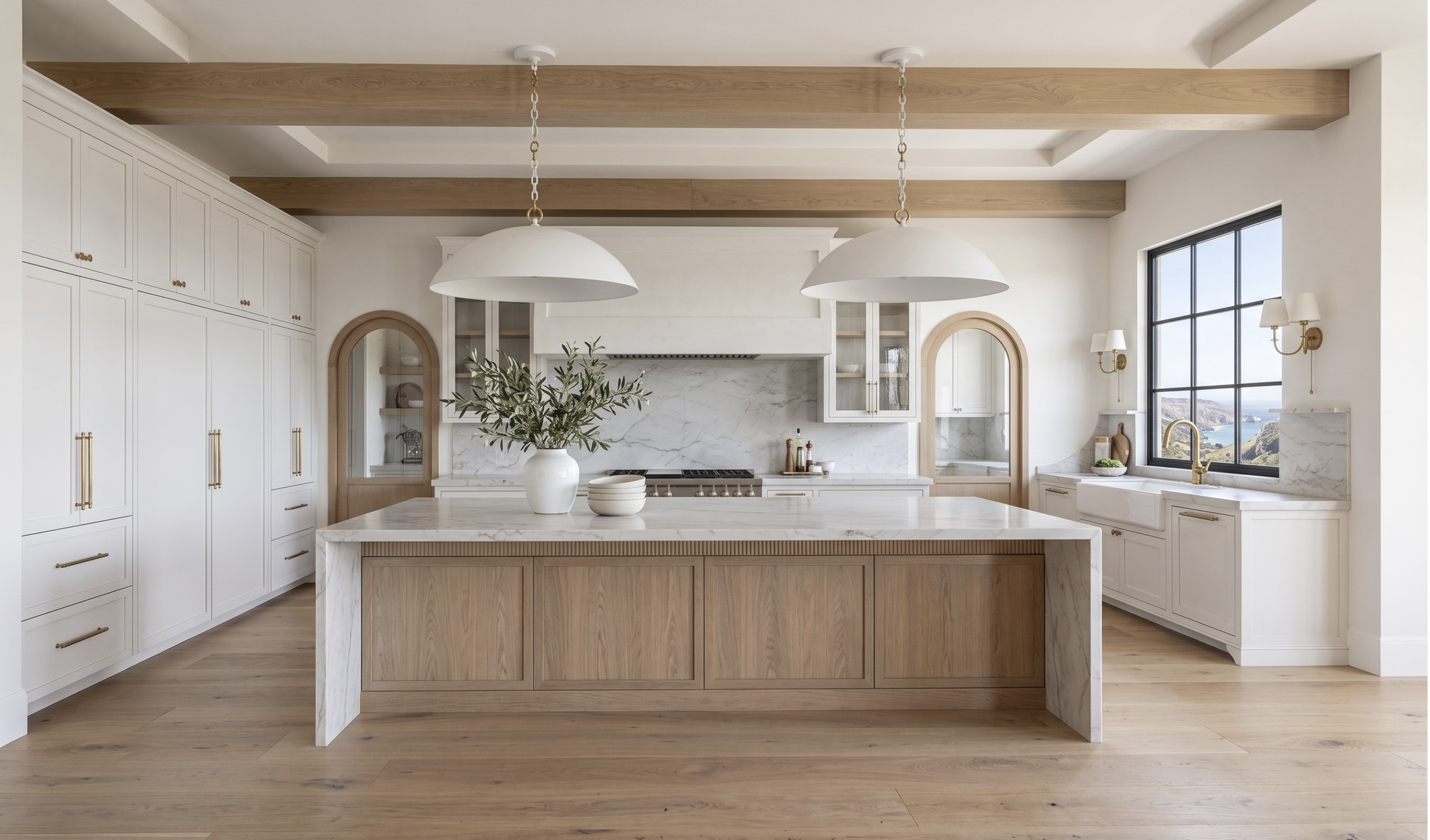 Spanish Mediterranean–inspired kitchen renovation with warm neutral custom cabinetry, quartzite countertops, arched detailing, and a fluted island designed with timeless, elevated warmth.