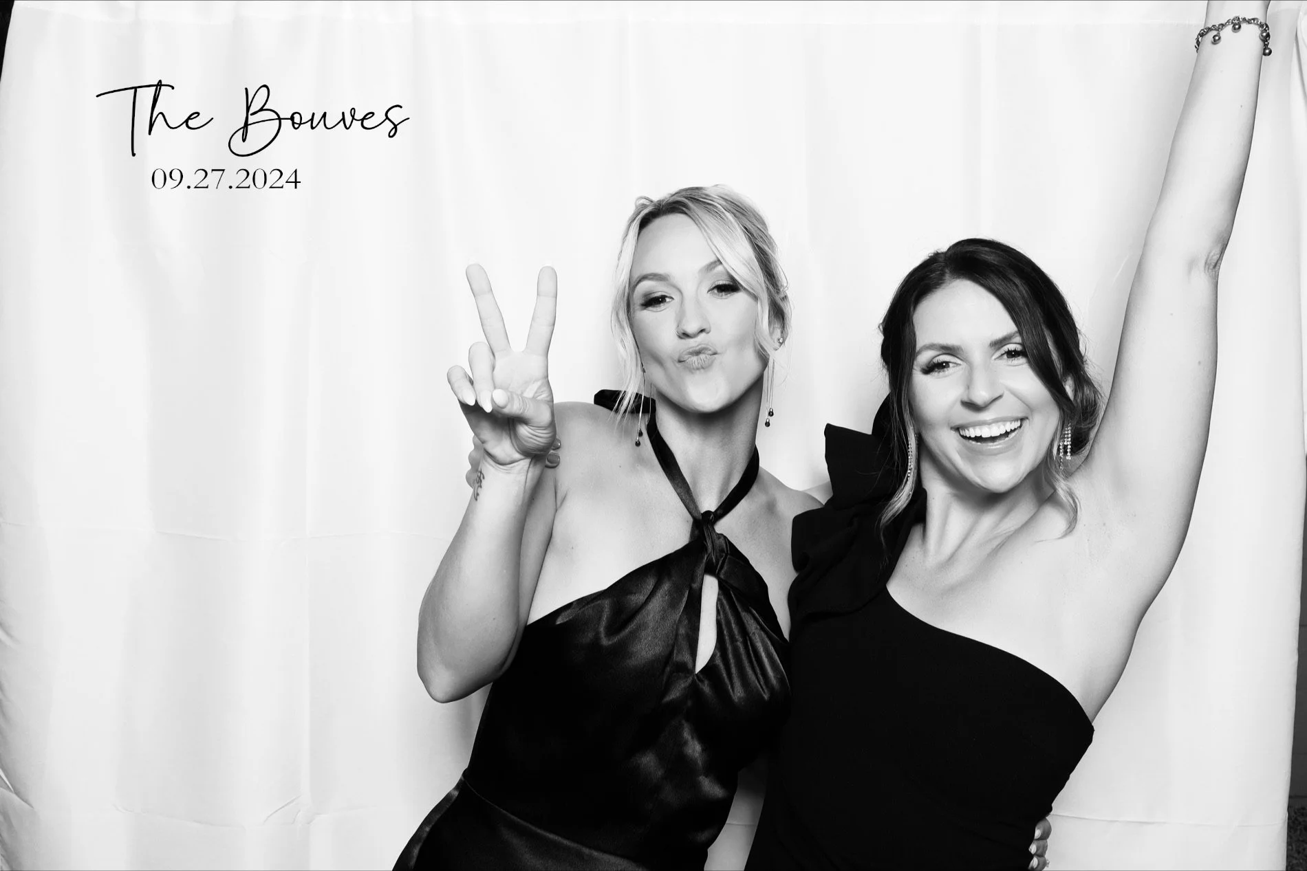 Two women celebrating at a wedding, one making a peace sign and the other raising her arm, with text on the left that says 'The Bouwen 09.27.2024'