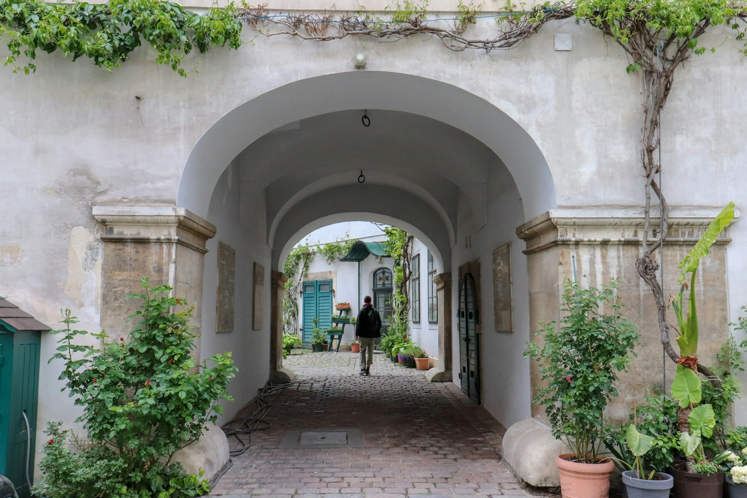 A man walking through an arched walkway