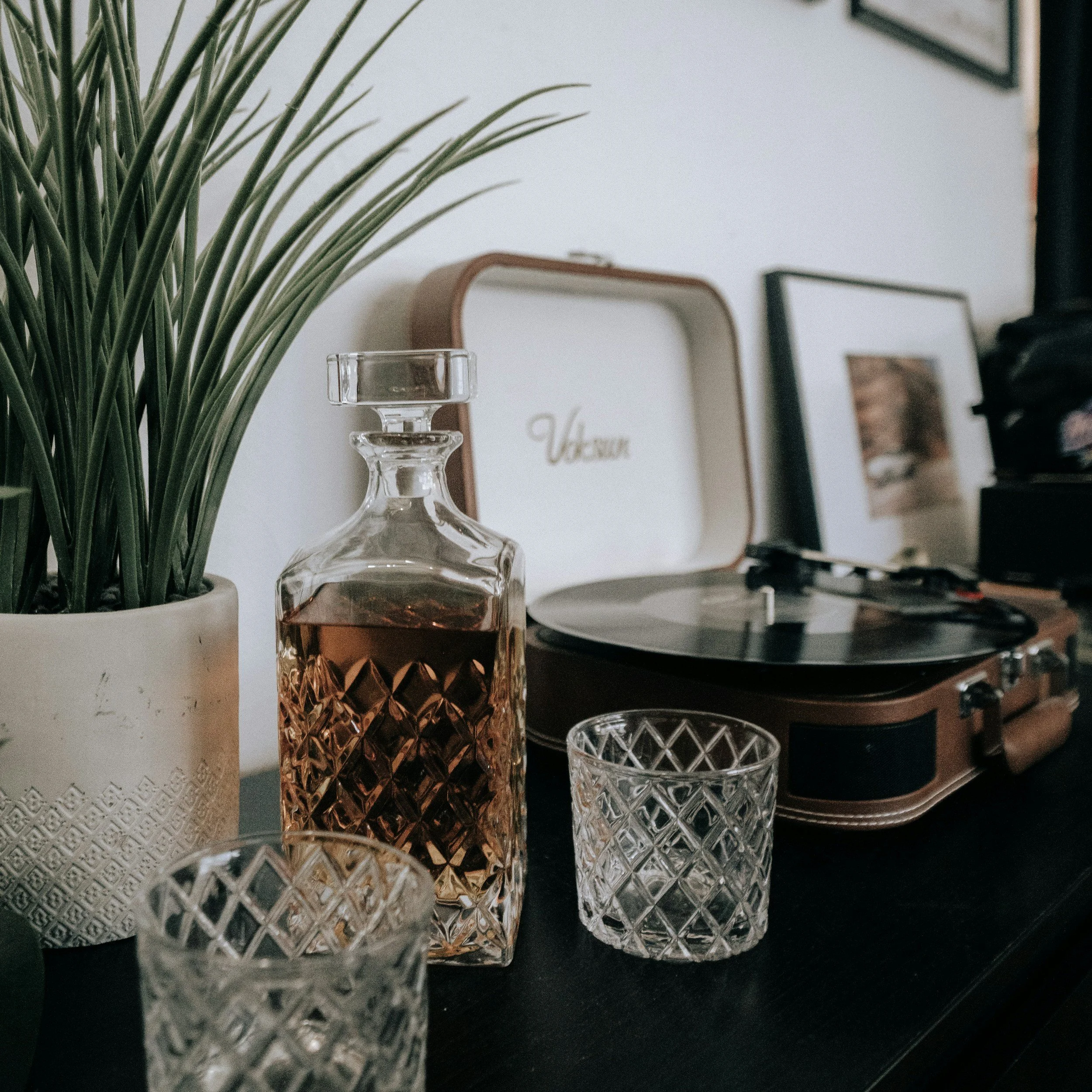 Decorative glassware and framed photos on a black surface.