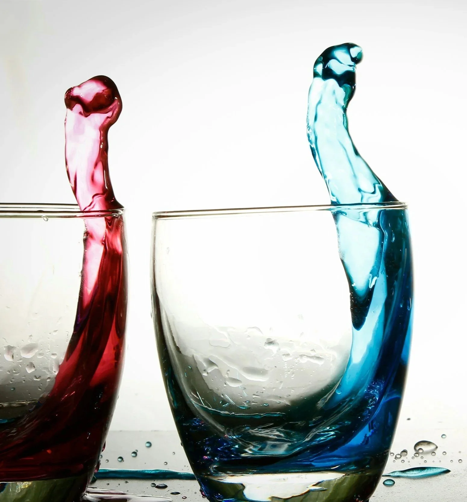 hard (red) water and soft (blue) water in two glasses with a white background.