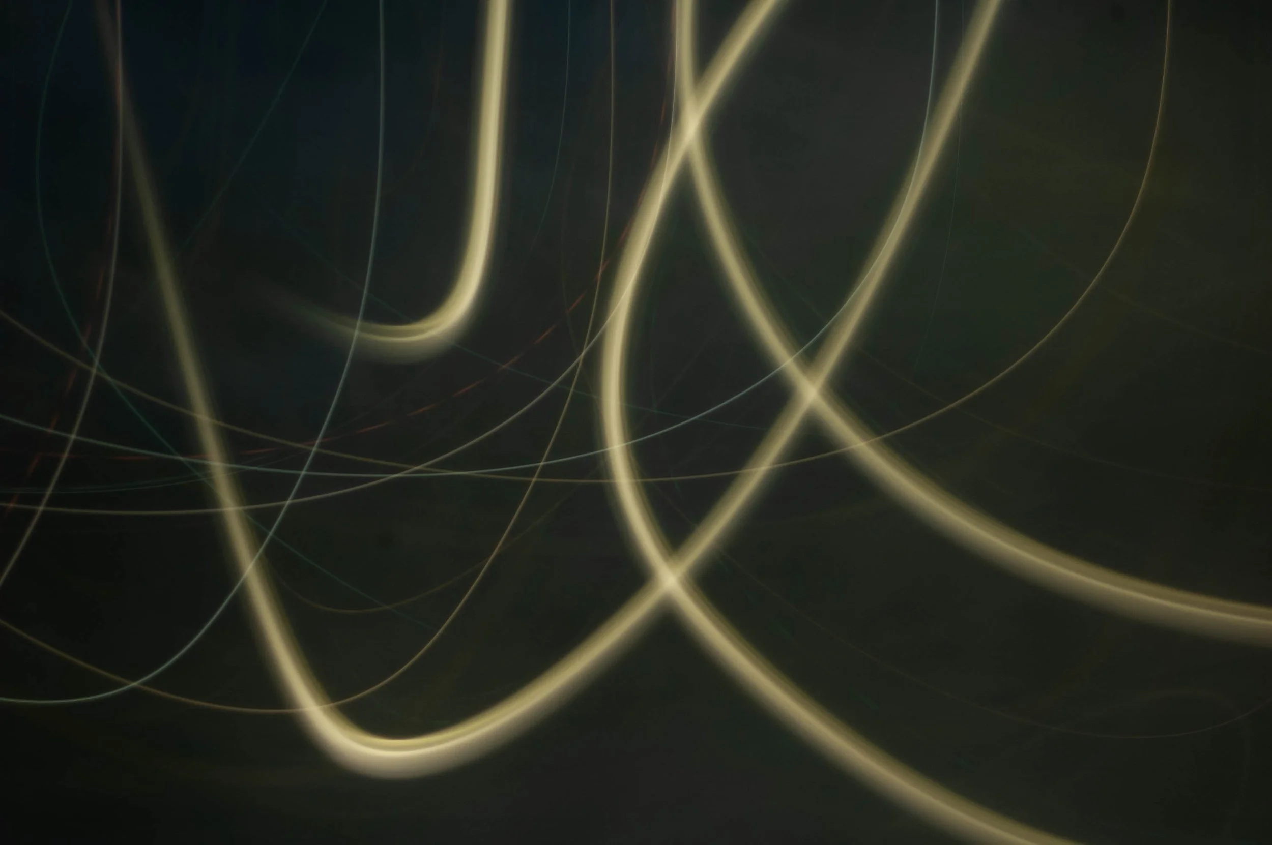 Threads of pale yellow light looping through a deep dark green background.