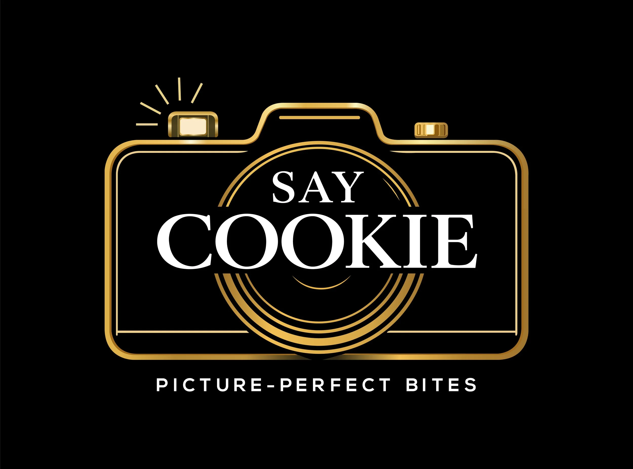 A decorative logo with a gold outline of a camera and the text "SAY COOKIE" in the center, with a subtitle "PICTURE-PERFECT BITES" below on a black background.