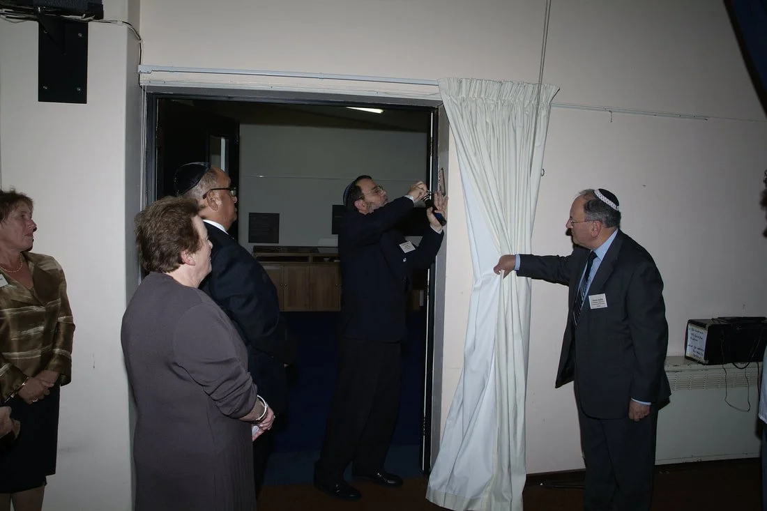 Rabbi Chaim Dovrat affixes a Mezuzah on the doorpost