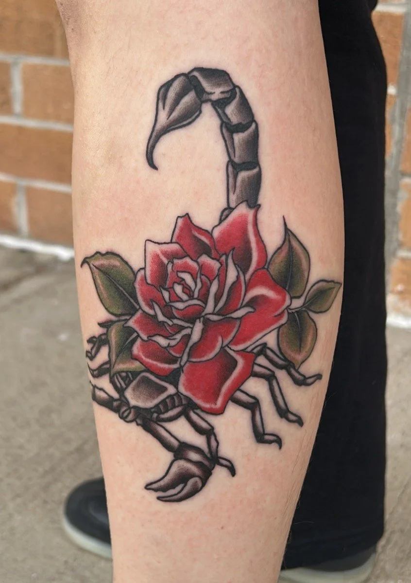 Tattoo of a red rose with green leaves on a scorpion's body done near Arvada, Colorado.