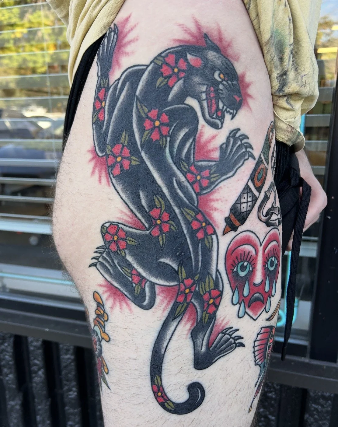 Tattoo of a black panther surrounded by red flowers finished in the Denver West metro area.