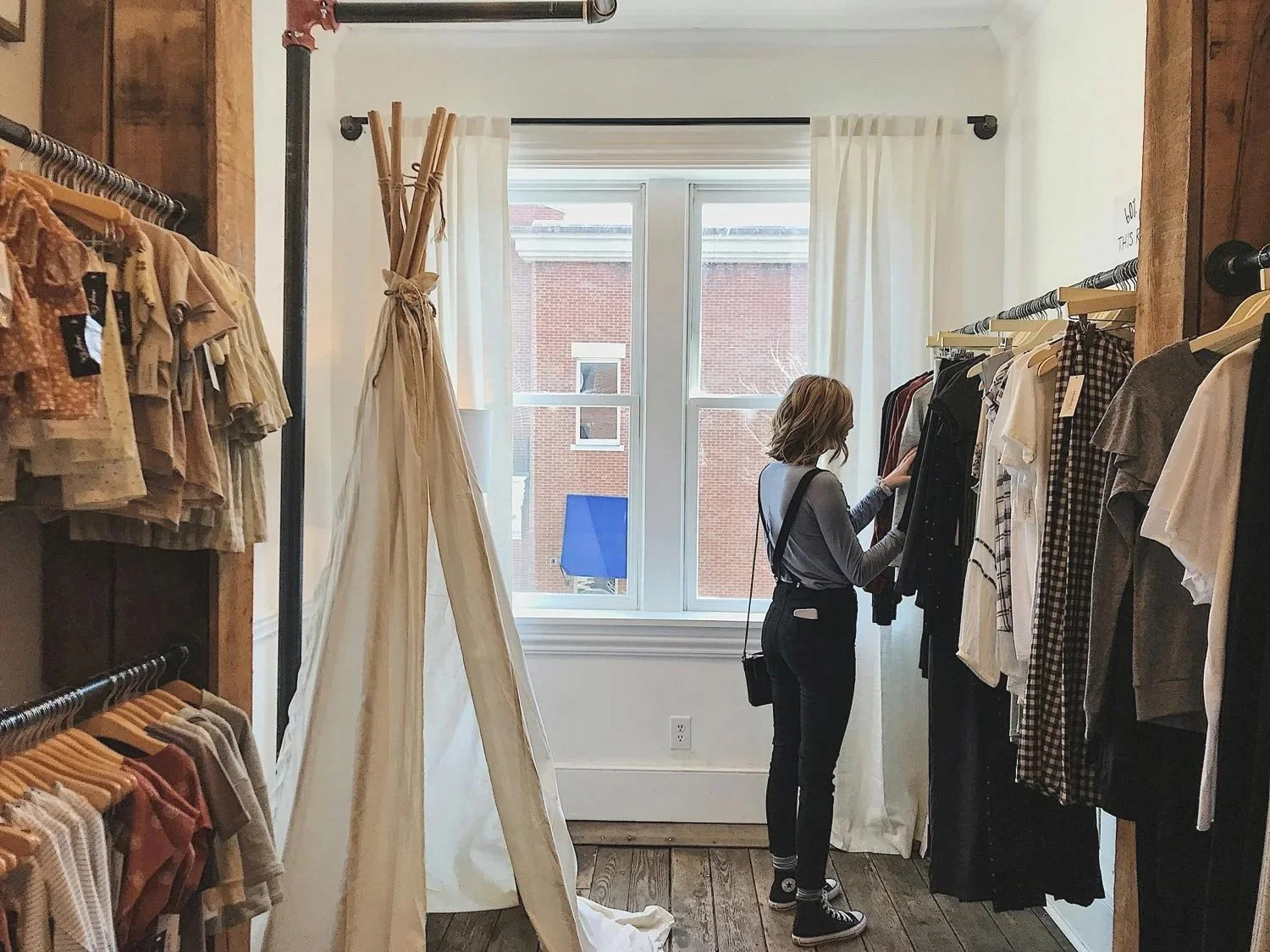 woman browsing through clothing racks while shopping