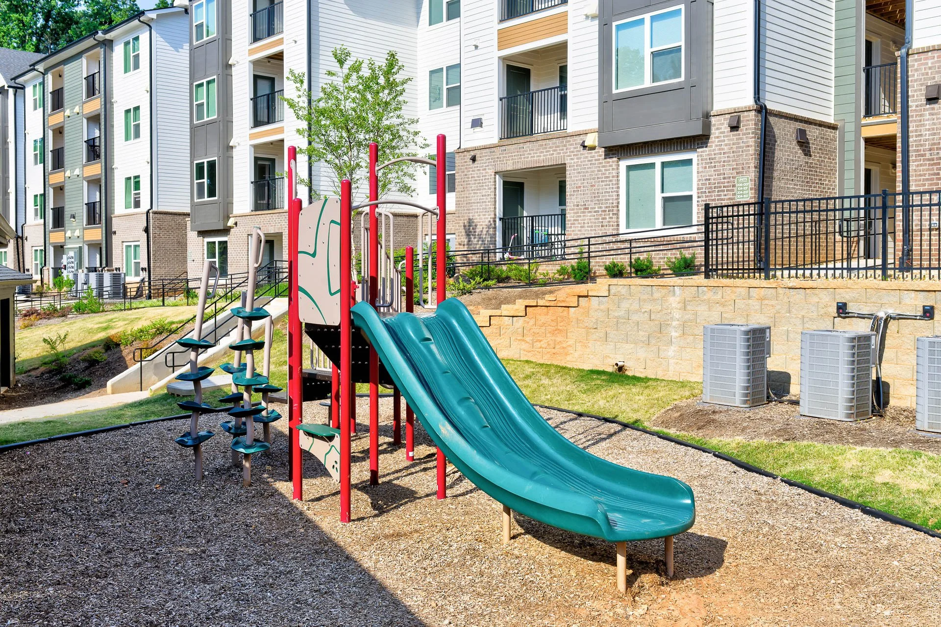 young girl climbing up a green slide