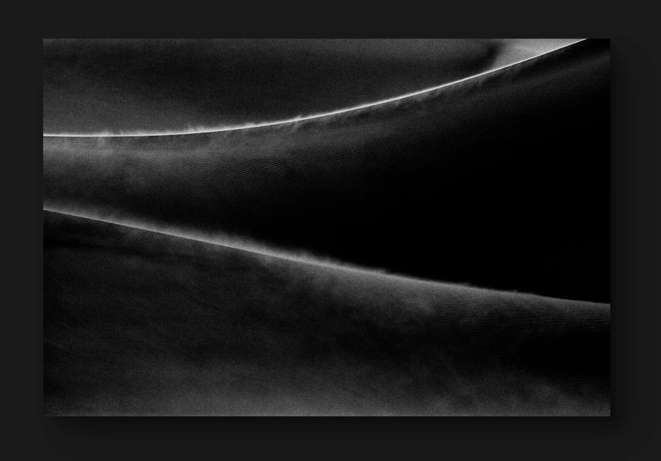 Une image en noir et blanc de formes courbes et lignes lumineuses abstraites.