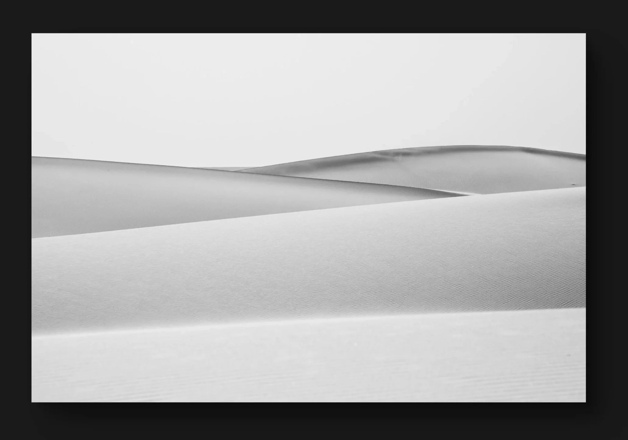 Dunes de sable dans un désert avec un ciel clair.