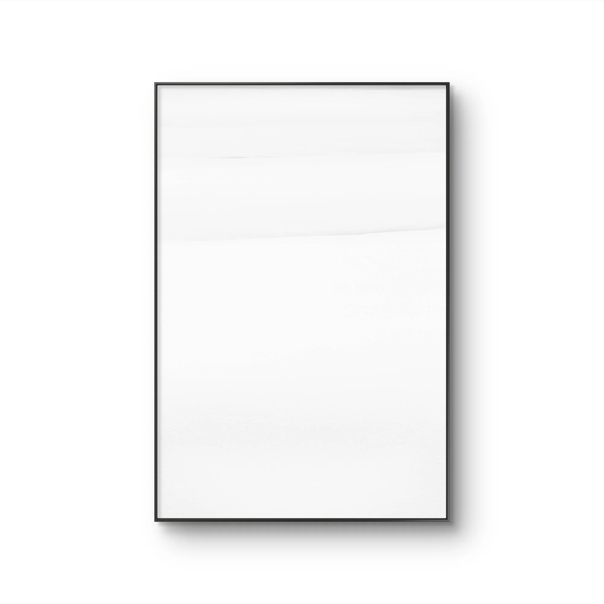 Un cadre noir contenant une feuille blanche suspendu au mur blanc.