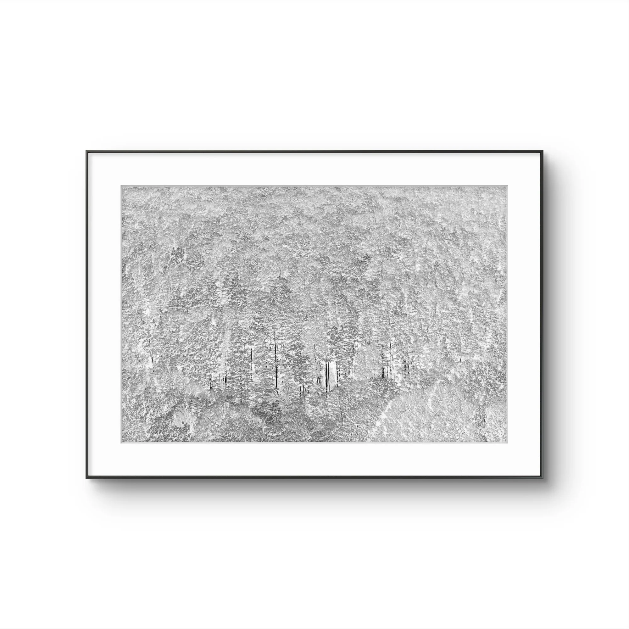Une œuvre d'art représentant une forêt enneigée avec des arbres dépouillés, sous un ciel gris, encadrée d'un cadre noir et suspendue à un mur blanc.