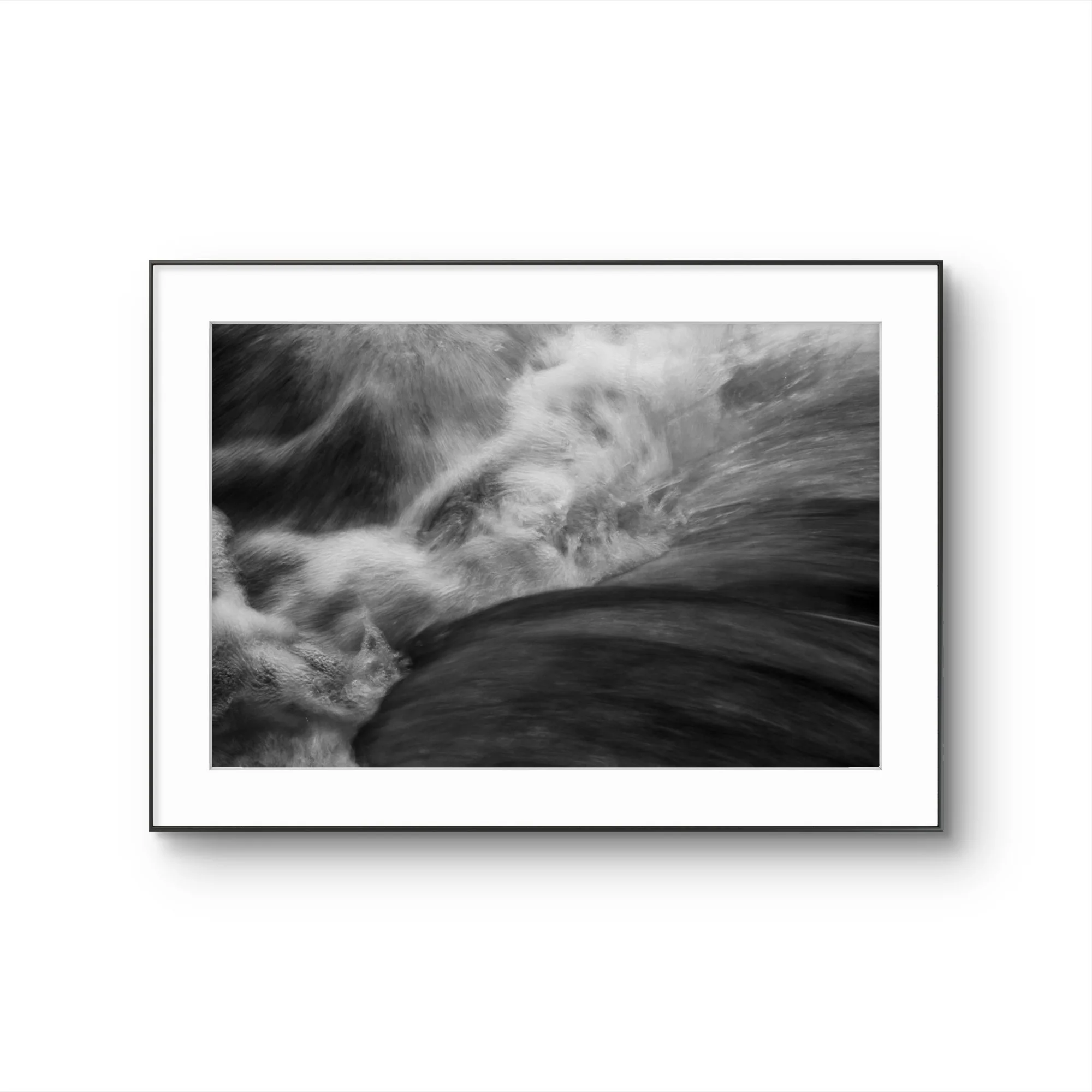 Une photographie en noir et blanc d'une mer agitée, avec des vagues entrainant de l'écume.