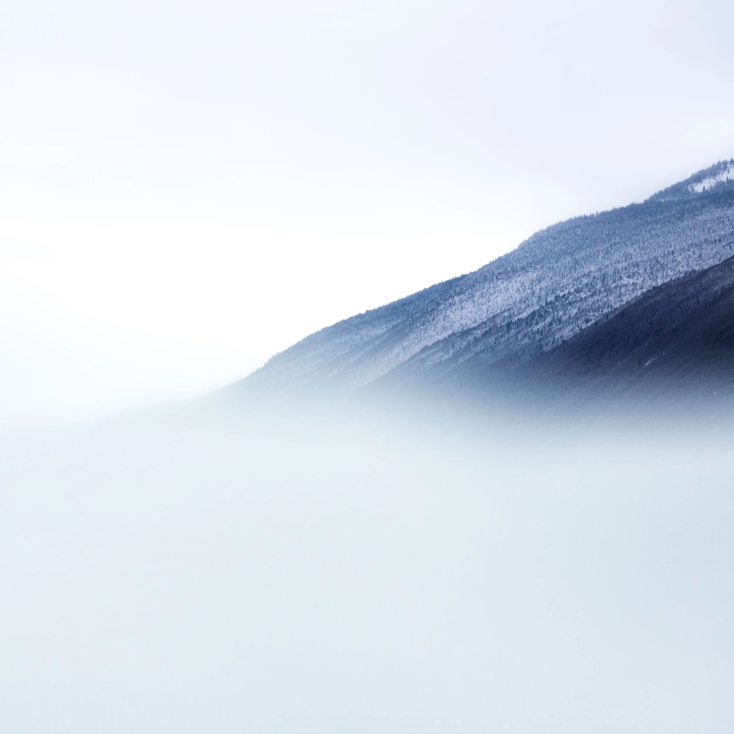 Vue d'une montagne enneigée sous un ciel nuageux.