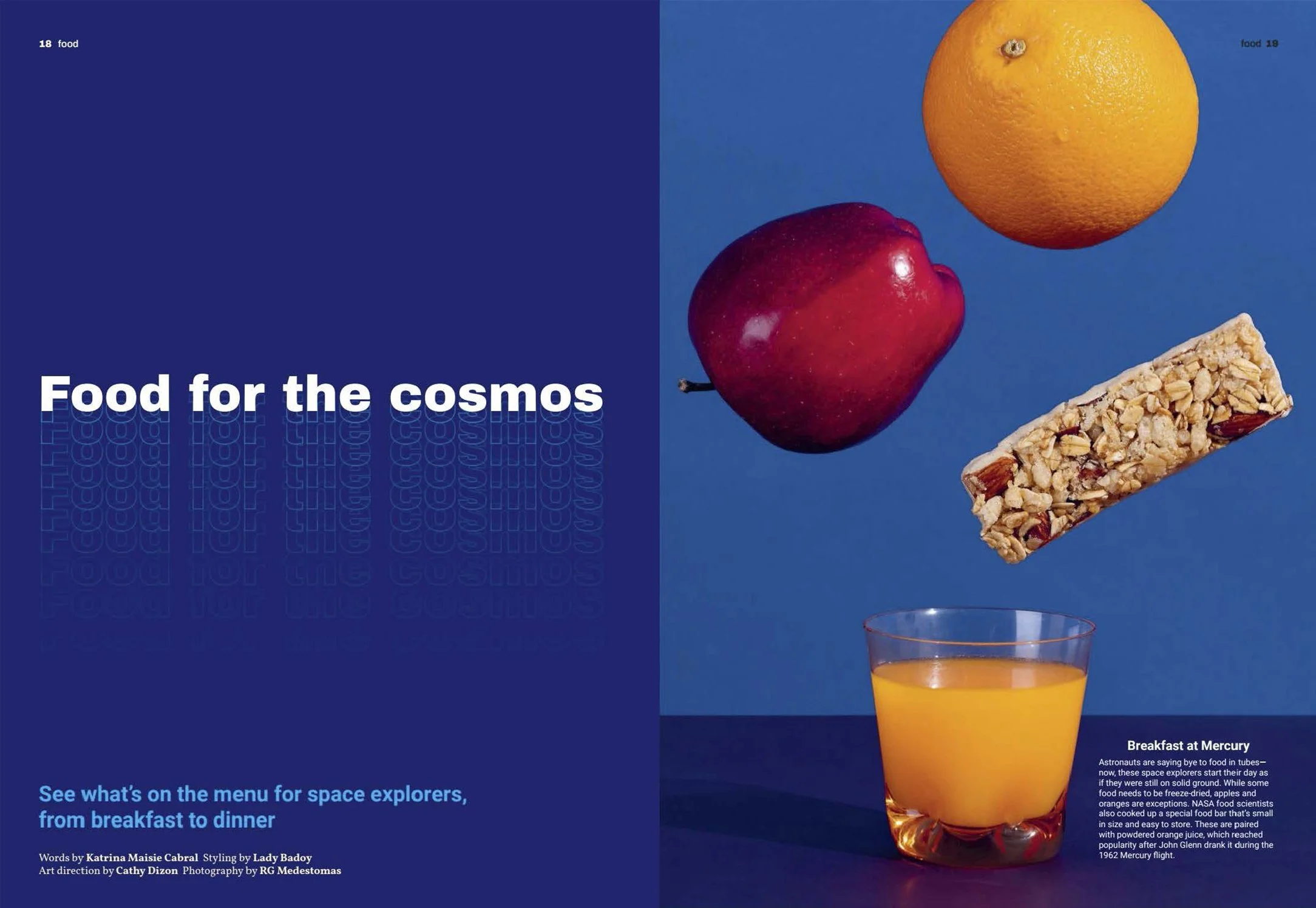 Magazine spread with title 'Food for the cosmos' on a blue background, featuring a photograph of a tall glass filled with orange juice, topped with a granola bar and fruits including an orange, apple, and lemon on a blue background.