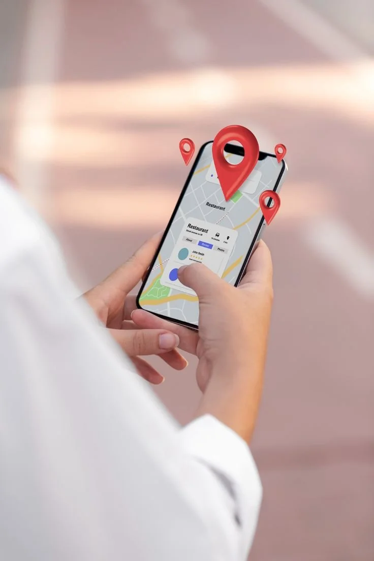 Person using a smartphone with a map and location pins on the screen