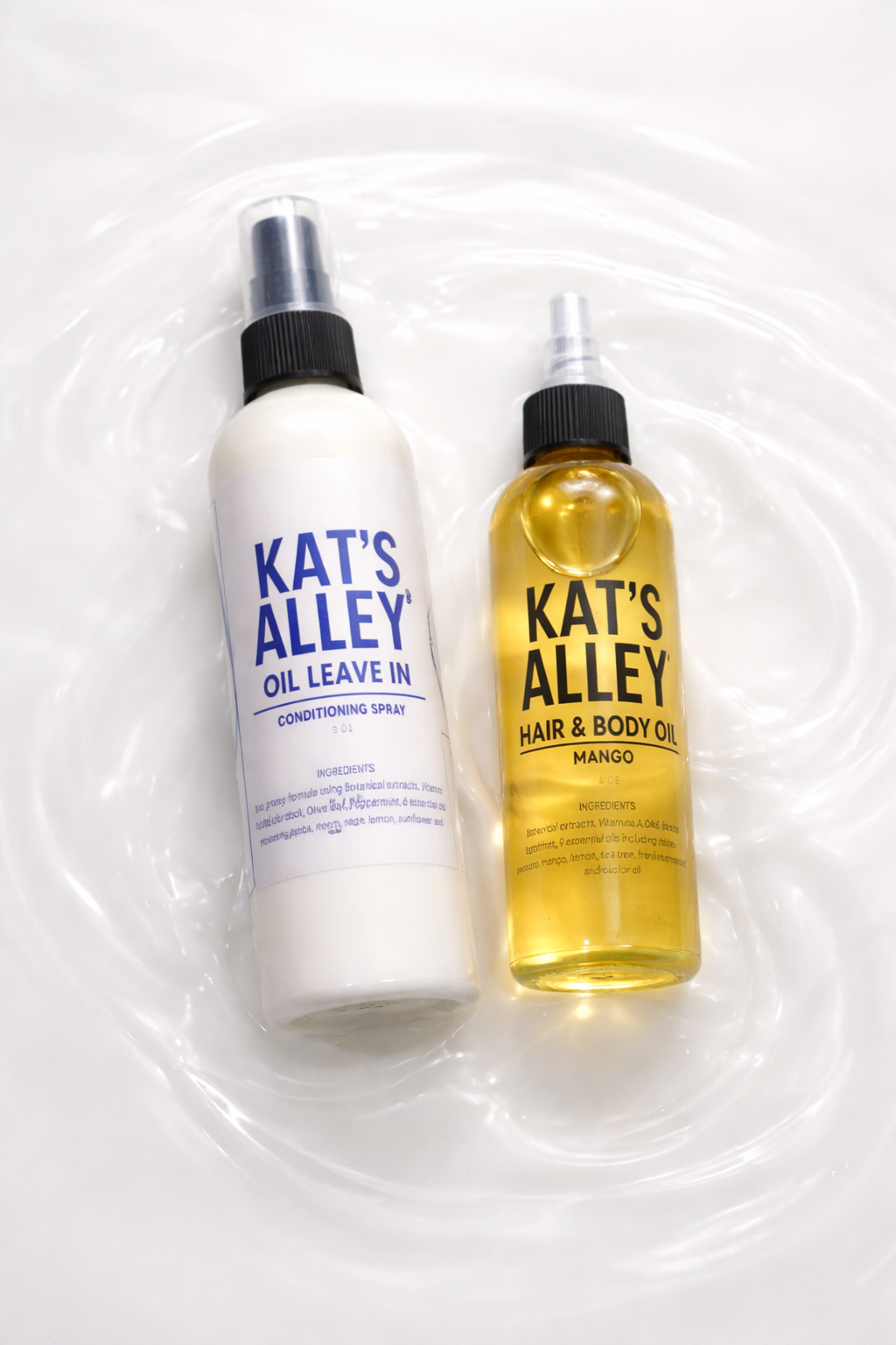 Two spray bottles from Kat's Alley, one labeled oil leave-in conditioning spray and the other hair and body oil with mango fragrance, floating in water.