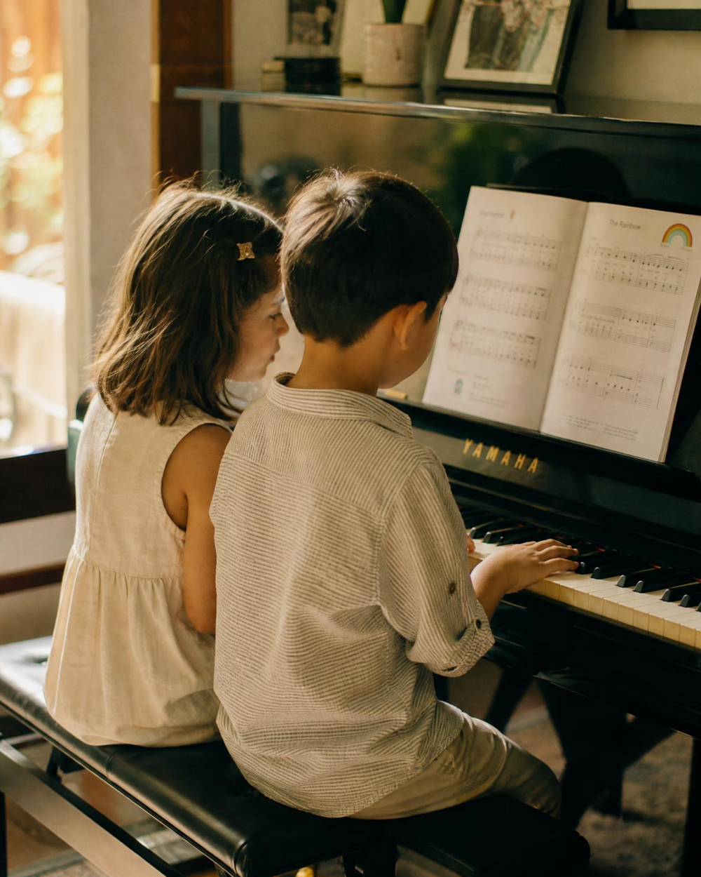 Two students sharing a piano lesson