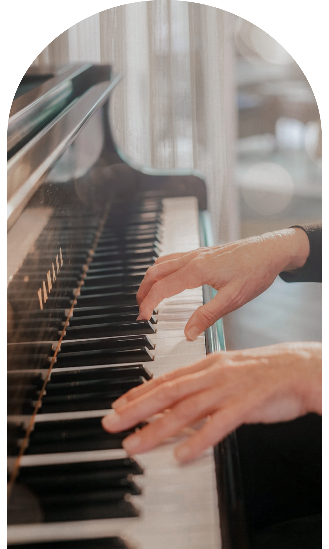 Hands playing an acoustic piano