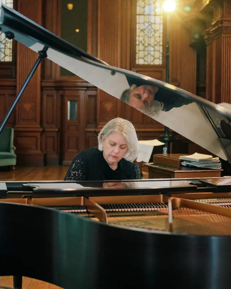 Amanda playing a grand piano.