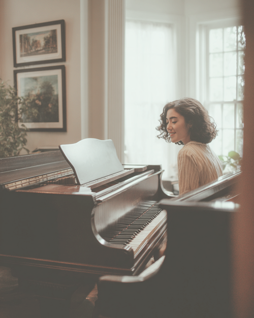 Adult student seated at a grand piano