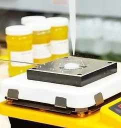 Laboratory setting with a microscope, test tubes, and yellow-capped containers.