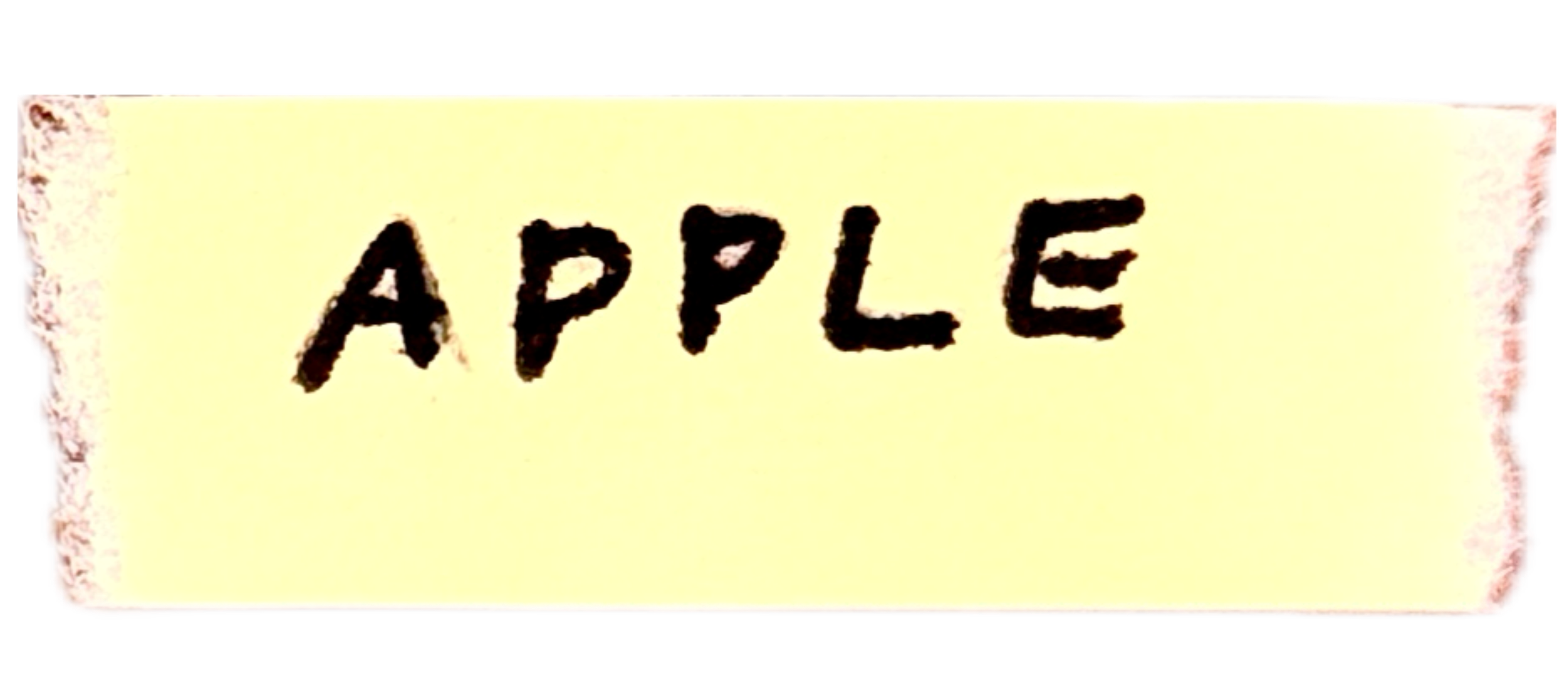 A torn piece of paper with the word 'APPLE' written in black ink.