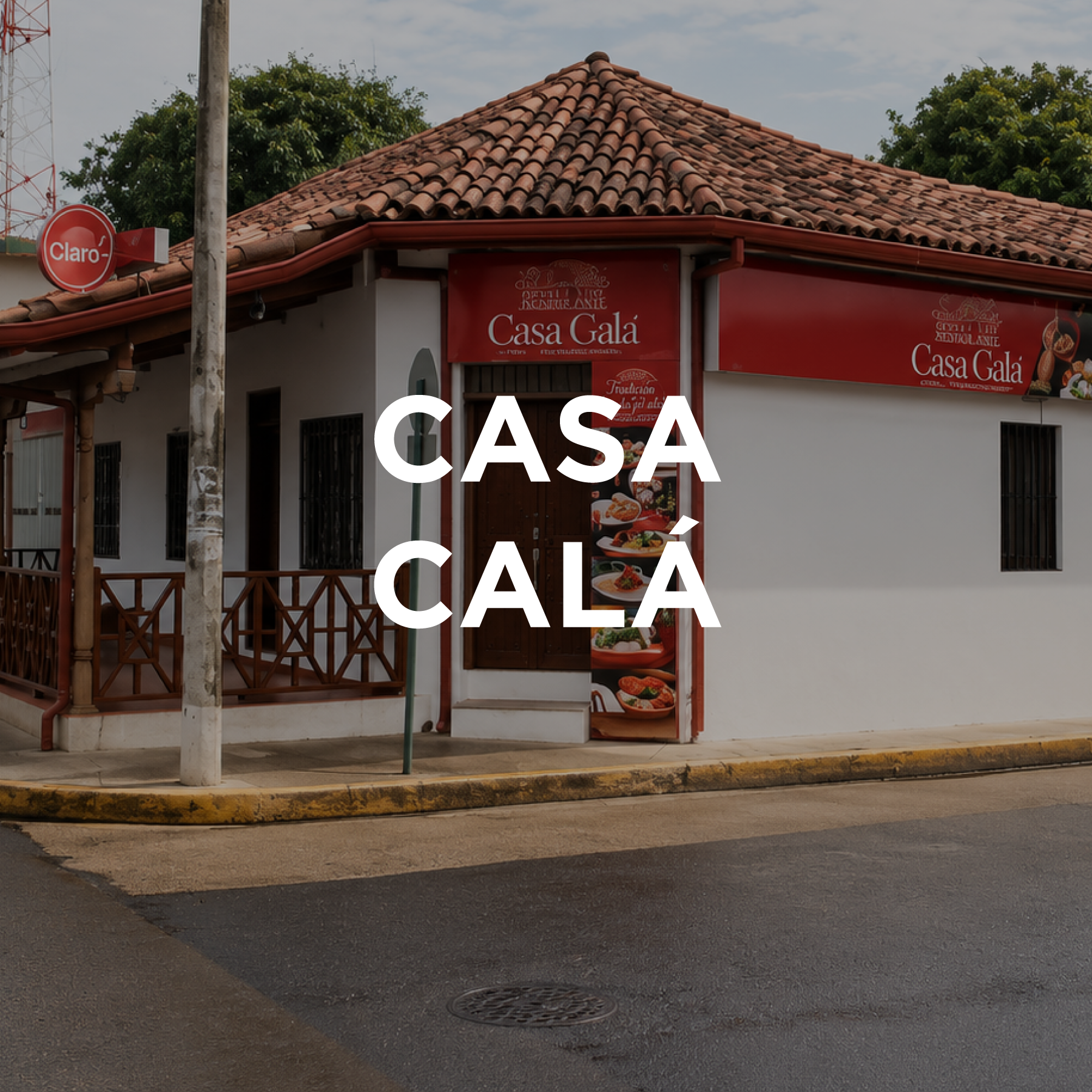 A building with a red tile roof and a white wall, part of a restaurant called Casa Gala with red signs displaying food images, situated on a street corner with a sidewalk and a storm drain visible in the foreground.