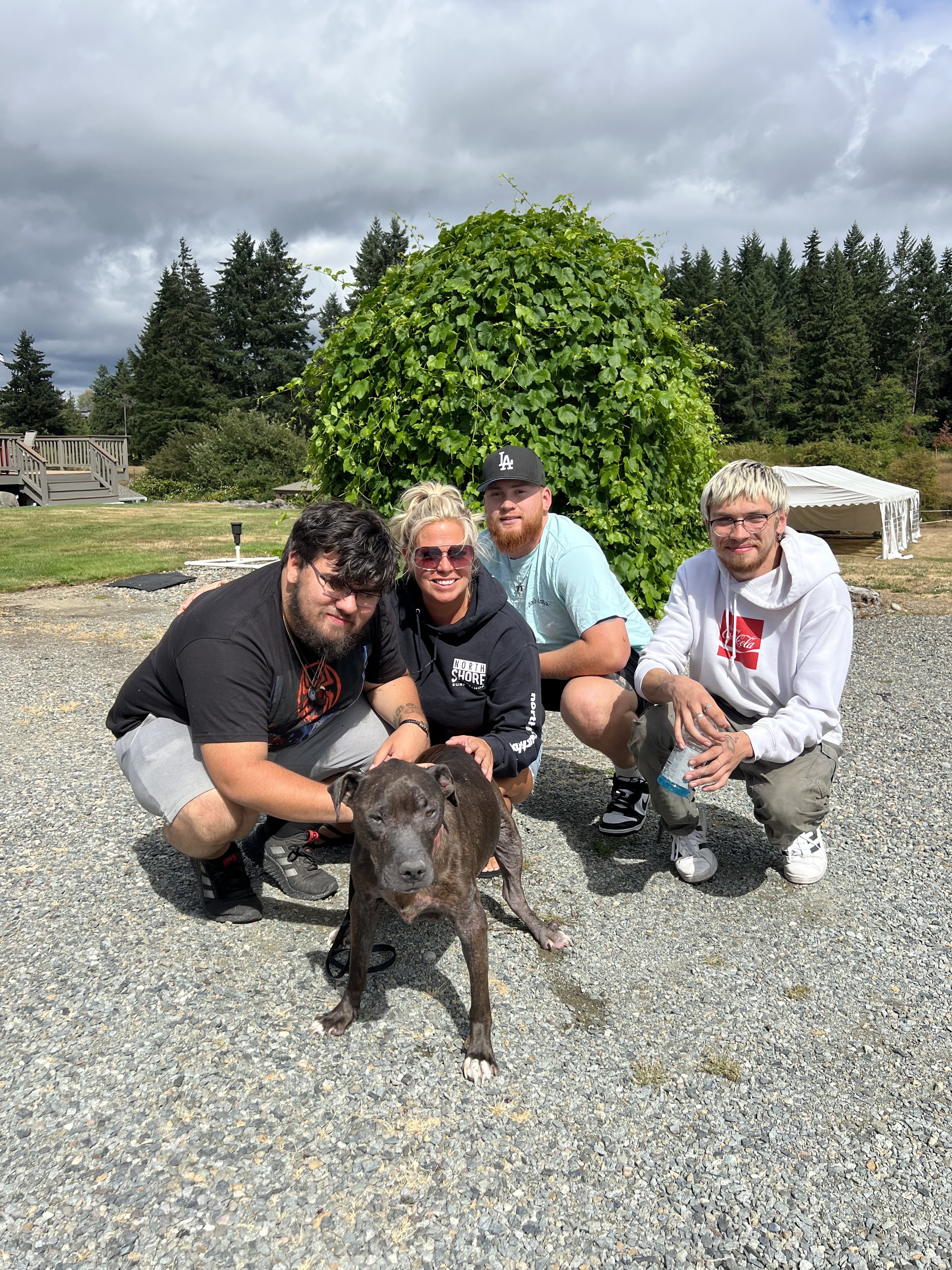 Bettina and her sons smiling with dog