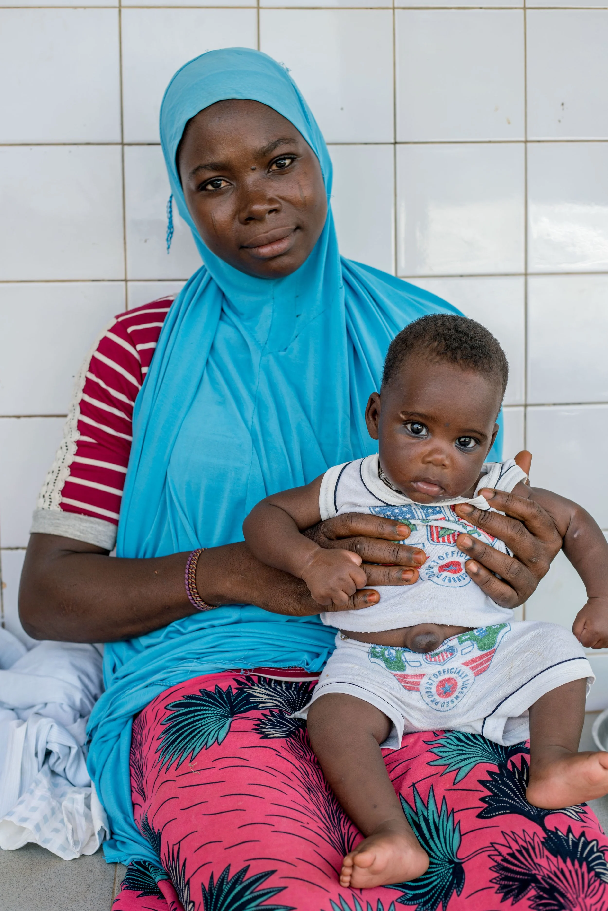portrait-of-a-mother-and-her-daugther-at-the-health-centre-of-binah-waiting-for-a-vaccination-2---reinier-van-oorsouw--unicef-togo----2019_49248987492_o.jpg
