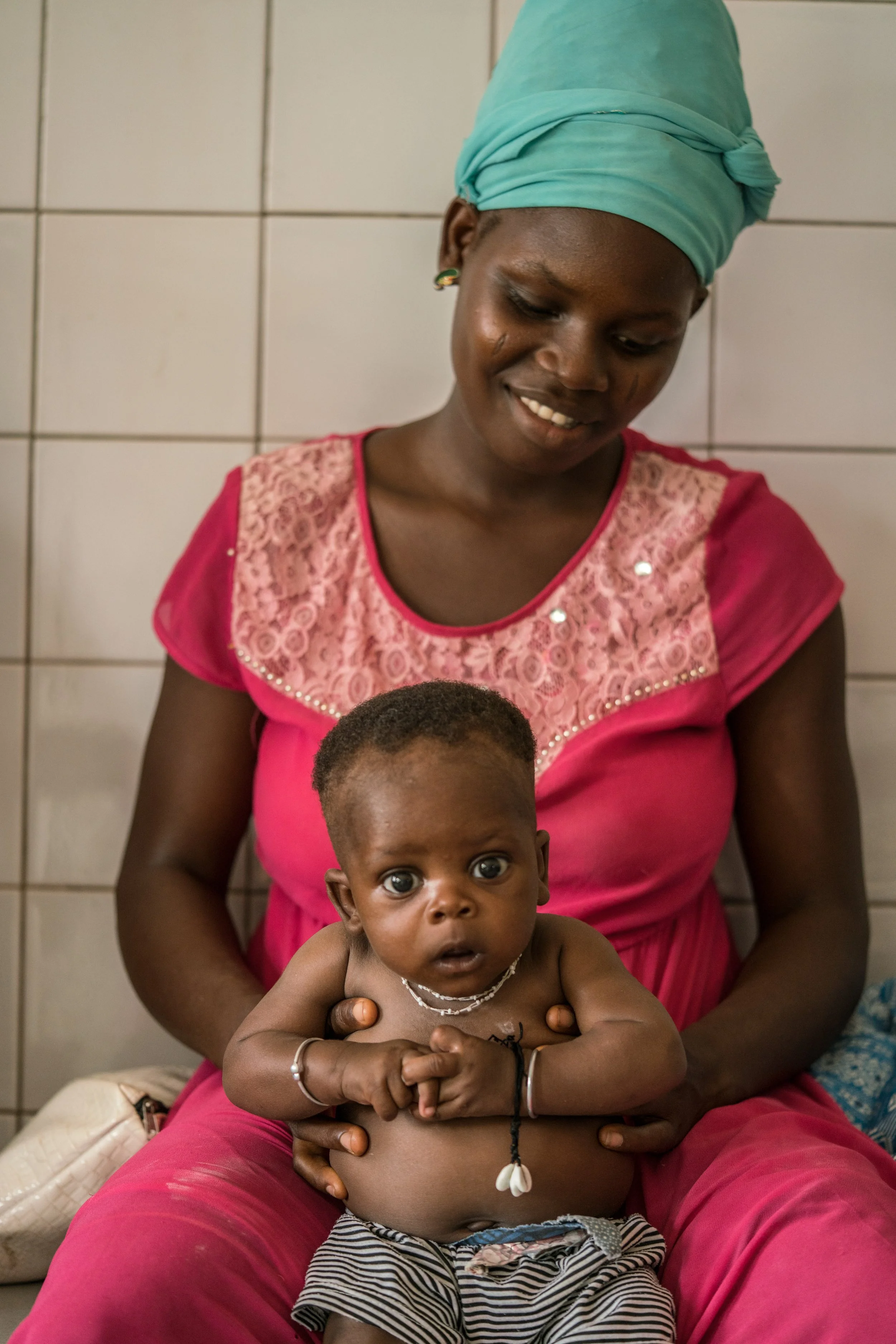 portrait-of-a-mother-and-her-daugther-at-the-health-centre-of-binah-waiting-for-a-vaccination-2---reinier-van-oorsouw--unicef-togo----2019_49248994157_o.jpg