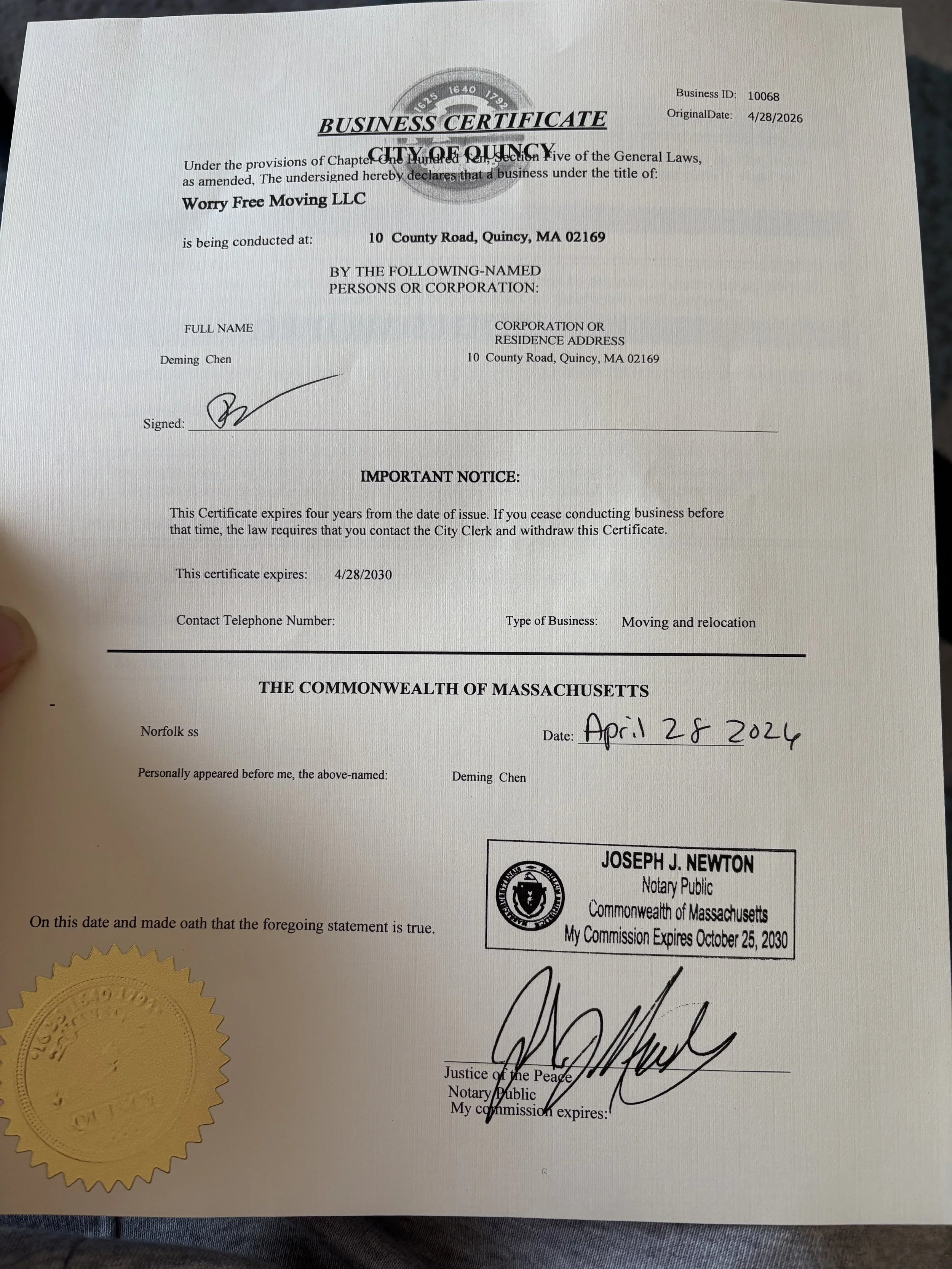 A legal document featuring a gold embossed seal, signatures, and official stamps. The document is a business certificate issued to Worry Free Moving LLC in Quincy, Massachusetts, dated April 28, 2026, with a notation of expiration on April 28, 2030, and signed by Joseph J. Newton, a notary public.