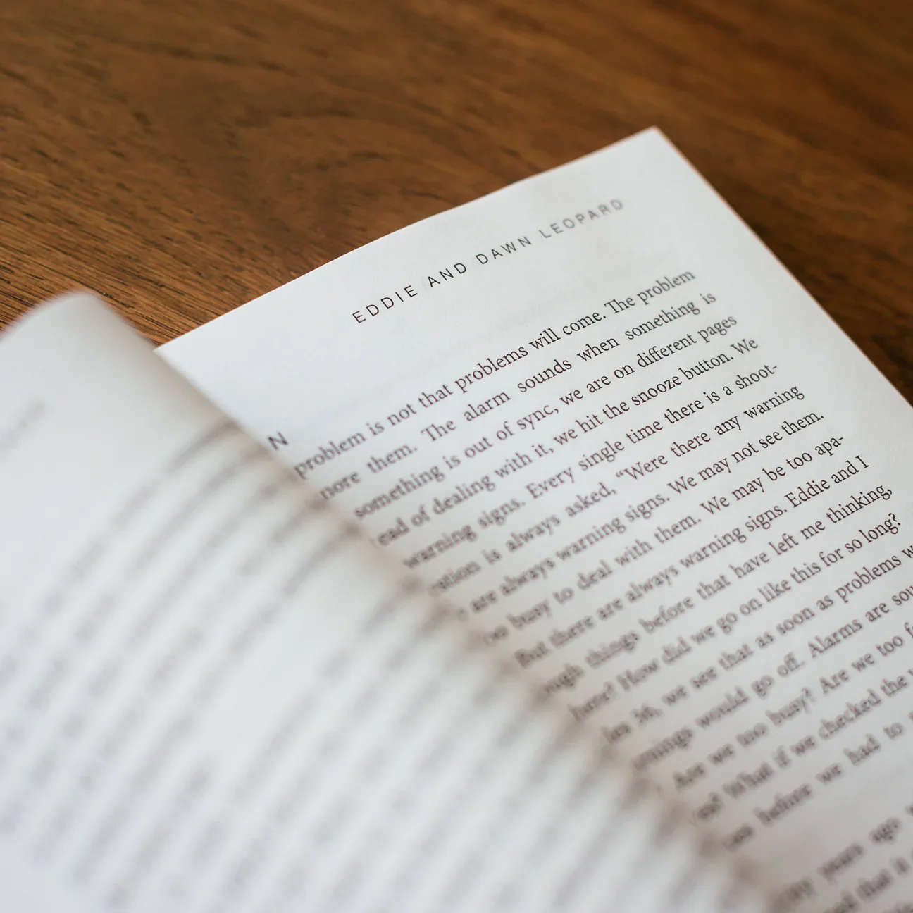 Close-up of a page in a book titled 'Eddie and Dawn in Leopard' resting on a wooden table.