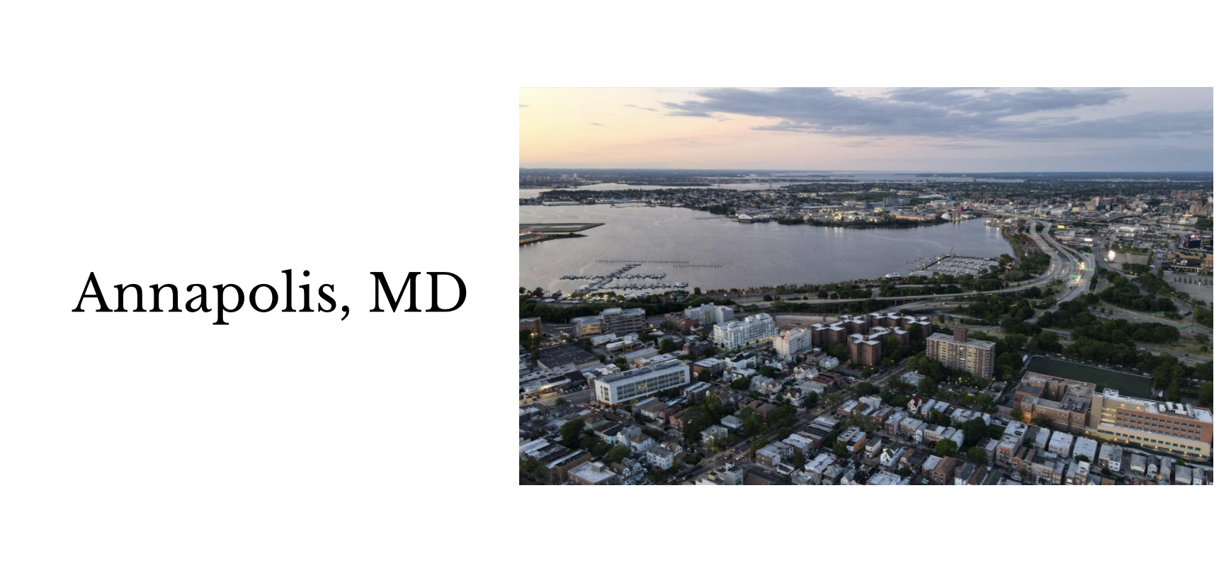 An aerial view of Annapolis, Maryland, showing the waterfront, marina, roads, and cityscape at dusk.