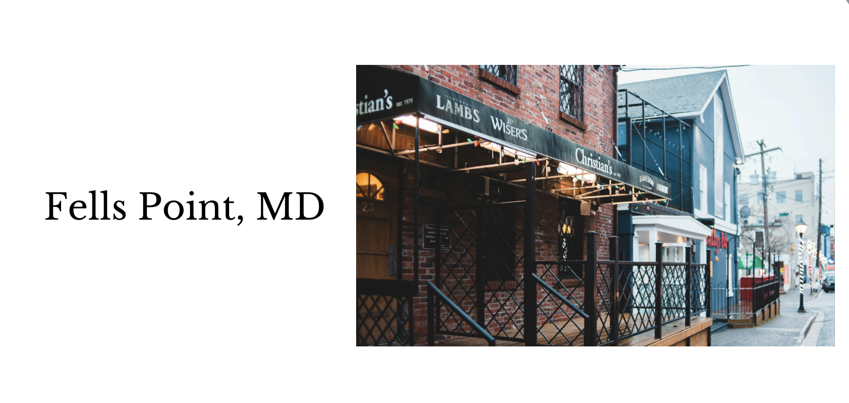 Street view of a historic brick building with a restaurant featuring a green awning and outdoor seating, located in Fells Point, Maryland.
