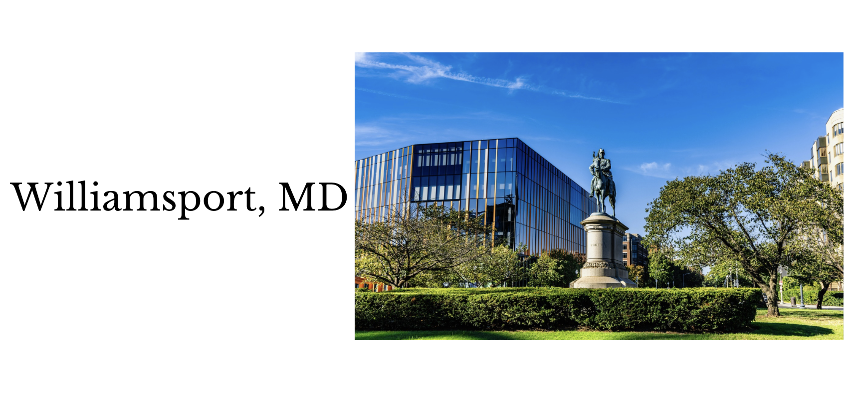 Photograph of a modern glass building with an equestrian statue in a park with trees and a clear blue sky, taken in Williamsport, Maryland.