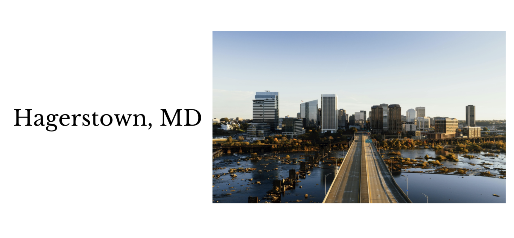 Skyline of Hagerstown, Maryland with a bridge over water leading towards tall buildings in the city.