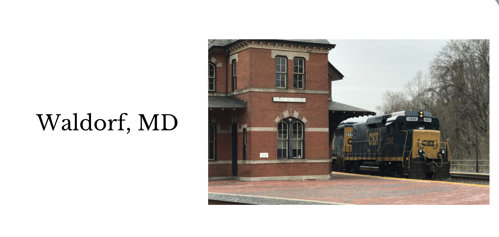 A train station with a brick building labeled 'Point of Rocks' and a CSX freight train on the tracks, set in Waldorf, Maryland.