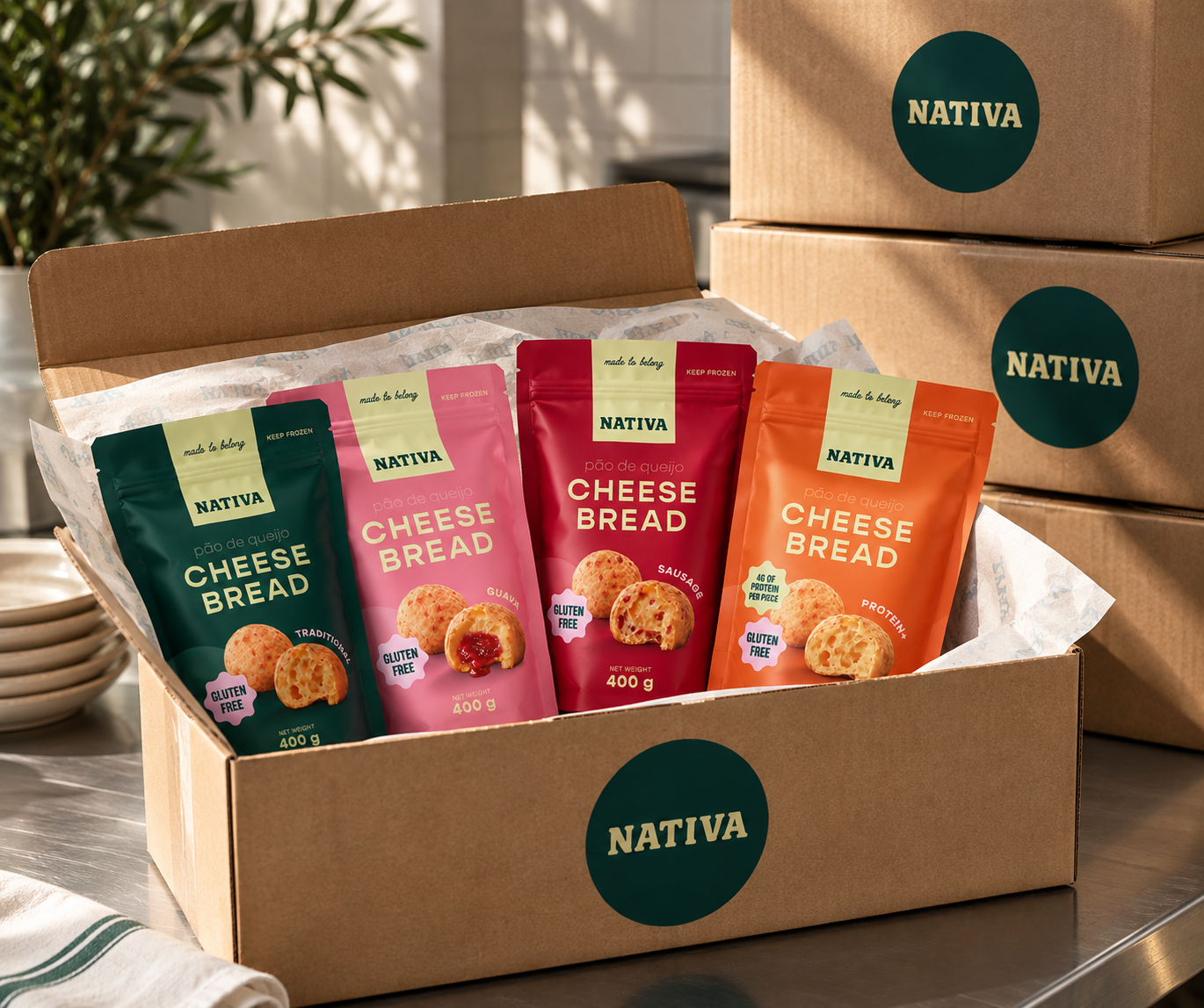 A cardboard box containing four varieties of Nativa cheese bread, each in colorful packaging, with two additional boxes in the background.