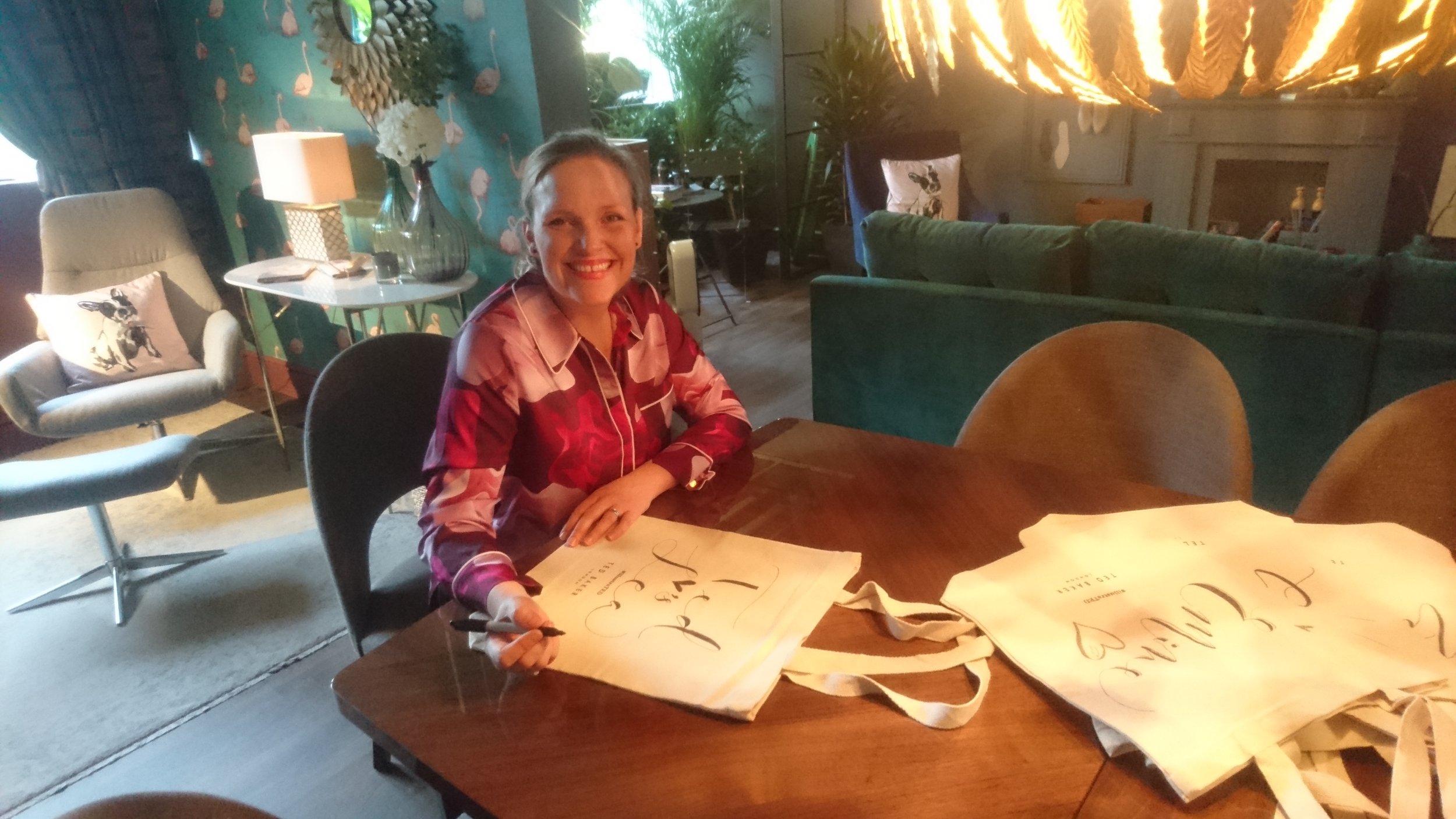 Kate Watson hand lettering Ted Baker tote bags in John Lewis showroom event