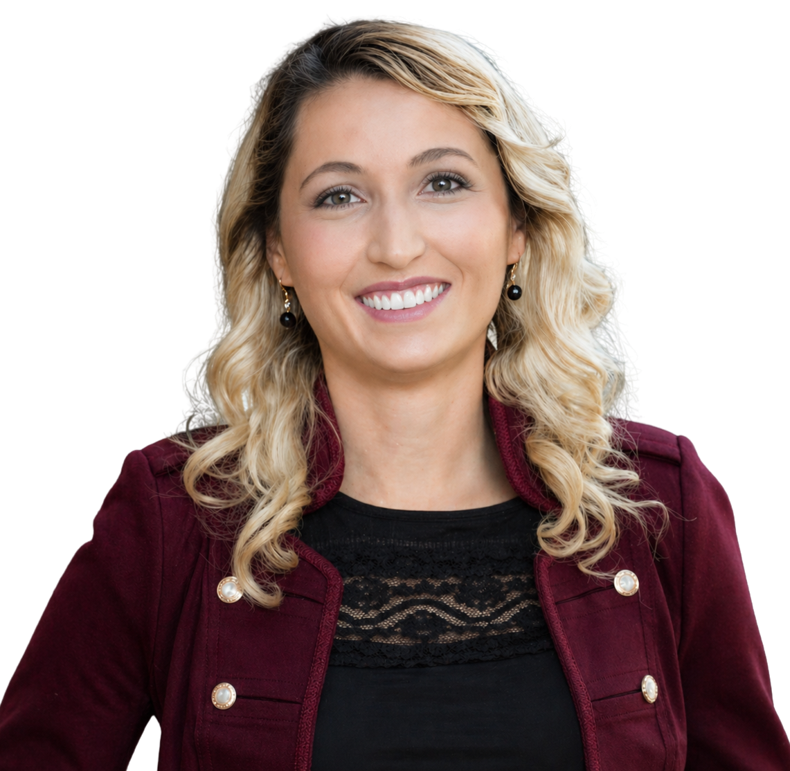 A smiling woman with blonde curly hair wearing a burgundy jacket and black top, with pearl earrings.