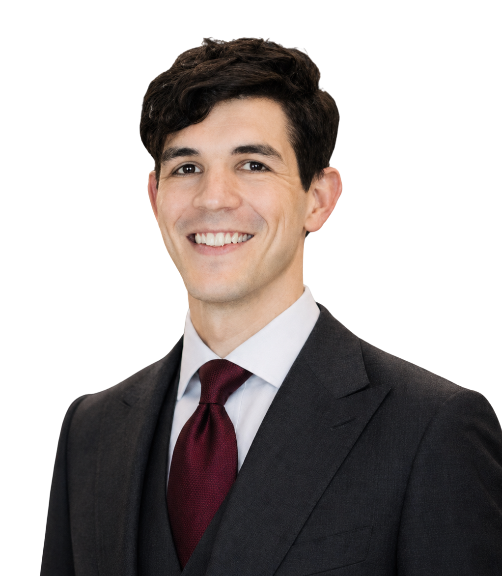 A young man in a black suit, white shirt, and burgundy tie, smiling and looking at the camera.