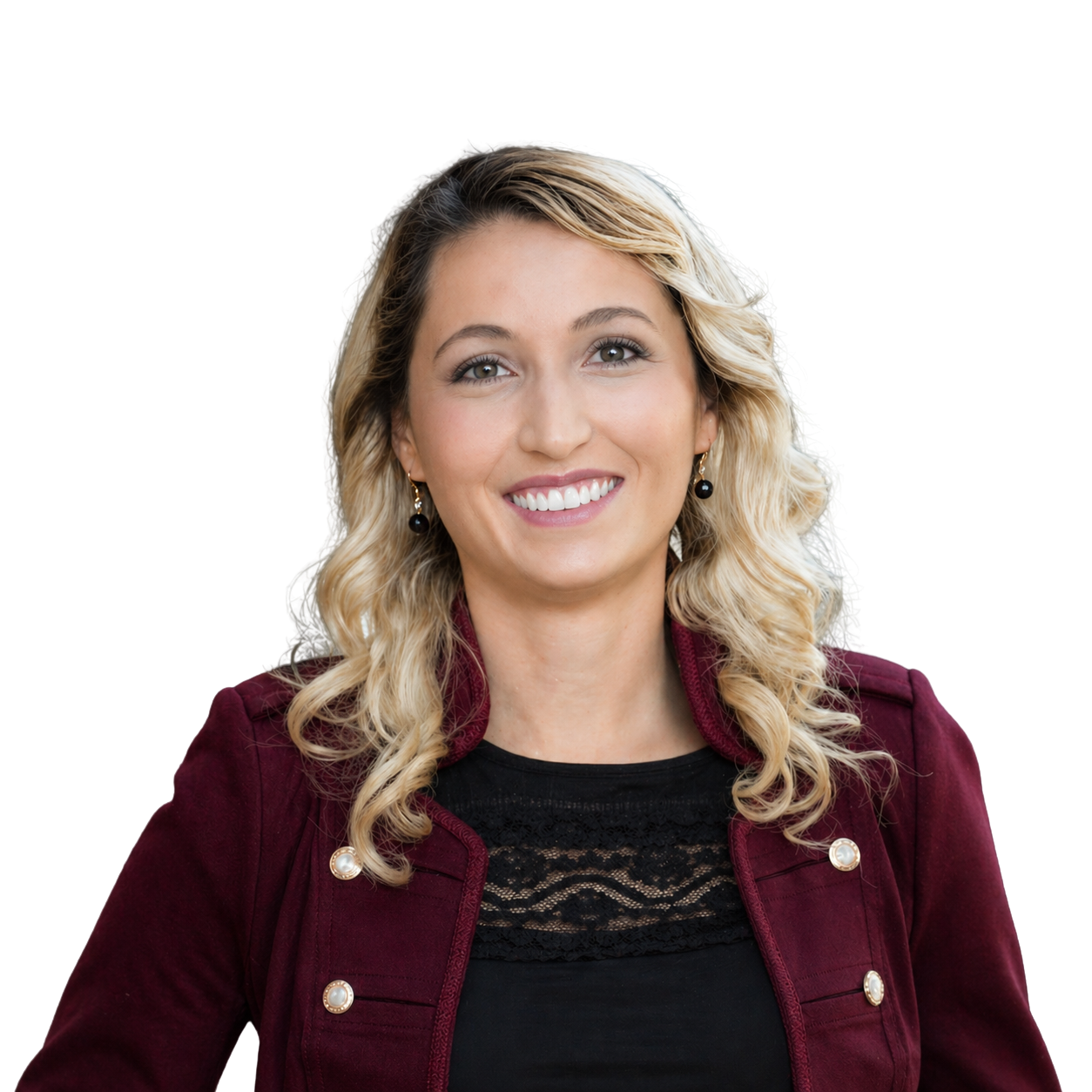 Portrait of a smiling woman with blonde, curly hair, wearing a maroon jacket with pearl buttons, a black lace top, and drop earrings.