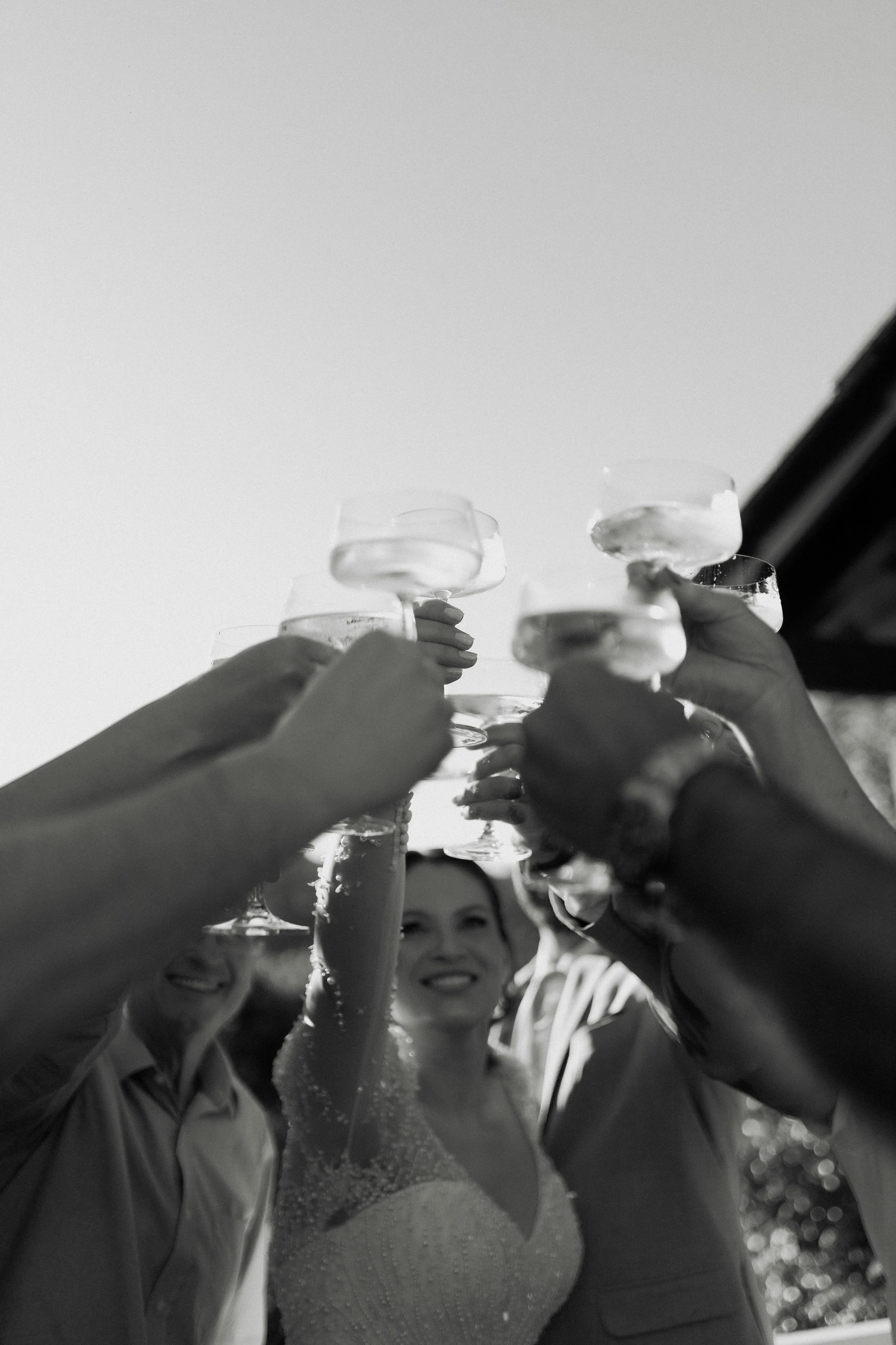 Group of women celebrating with champagne glasses raised in a toast outdoors.