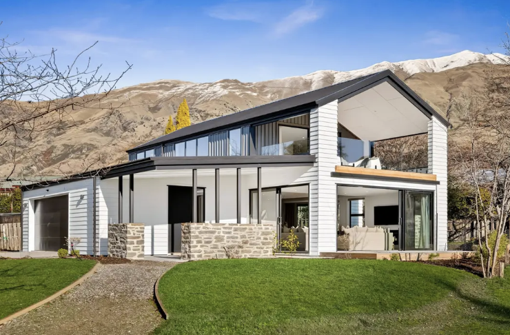 Looking up to a two storied home with mountains in the background - Wanaka Tree Escape a Wanaka holiday home managed by Be Our Guest