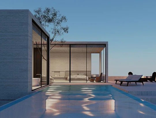 Modern house with large glass windows, a swimming pool, and outdoor lounge chairs on a patio under a clear blue sky.