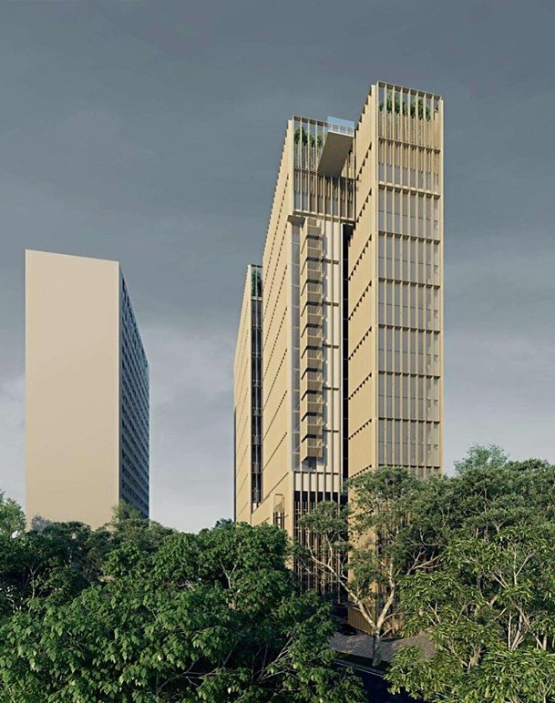 Tall modern office buildings with glass and beige facades surrounded by green trees under a cloudy sky.