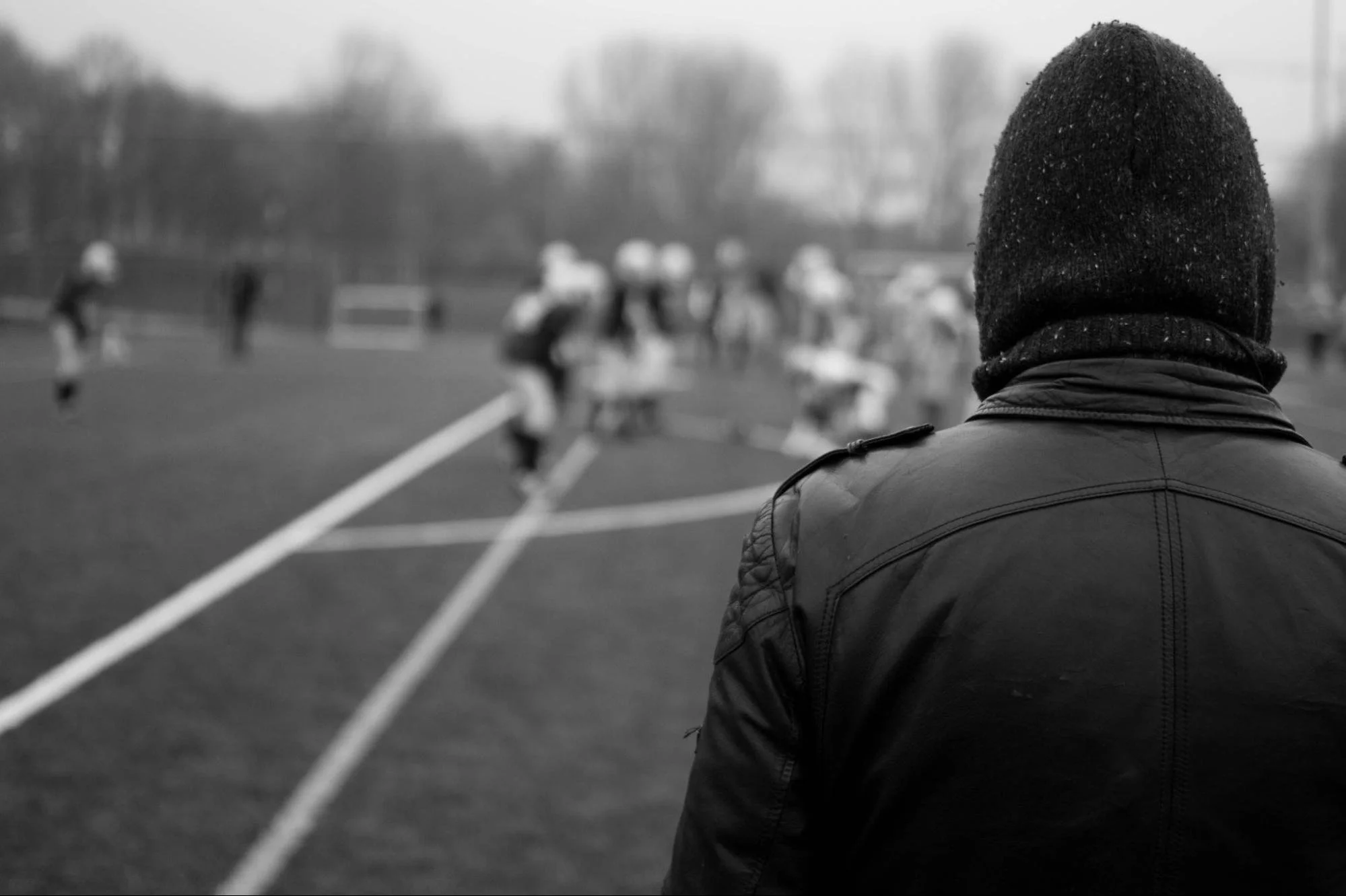 person sitting alone while looking at athletes
