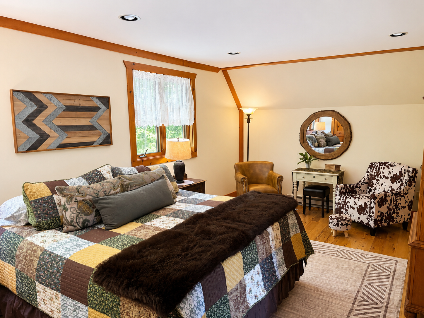 Spacious primary suite at Five Star Lodge featuring a king bed, comfortable sitting area, and luxury accommodations in the Adirondack Mountains near Gore Mountain in North Creek, NY.